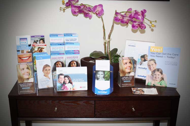 Dental brochures of Smile Brite Dental on a table and a purple orchid in a vase