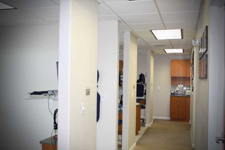 A hallway of a dentist office with walls and brown cabinets