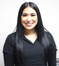 A female with black  hair wearing a black scrubs
