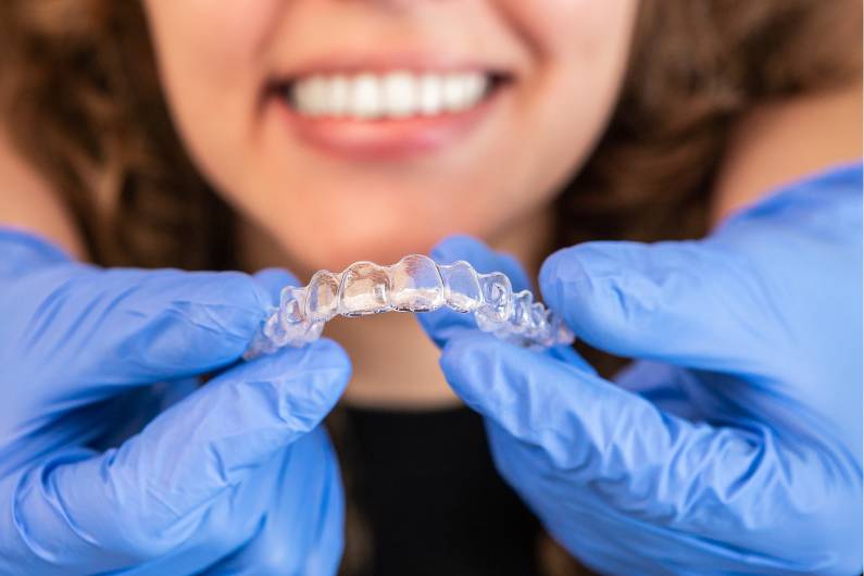 Orthodontist Doctor Putting Silicone Invisible Braces on Woman Teeth